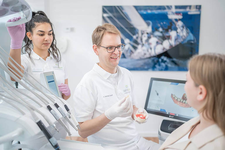 Dr. Andreas Levin erklärt einer Patientin das weitere Vorgehen für einen Zahnersatz