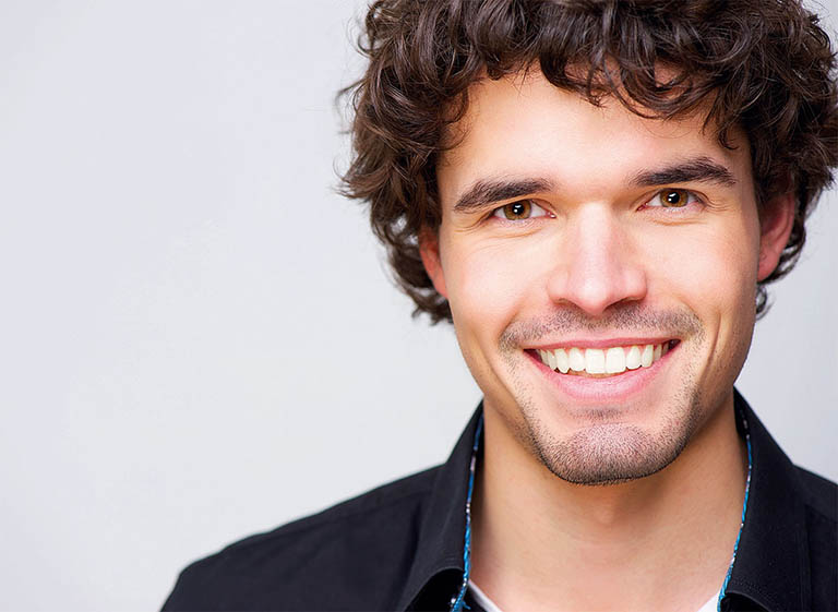 Portraitbild eines Mannes mittleren Alters mit makellosen weißen Zähnen