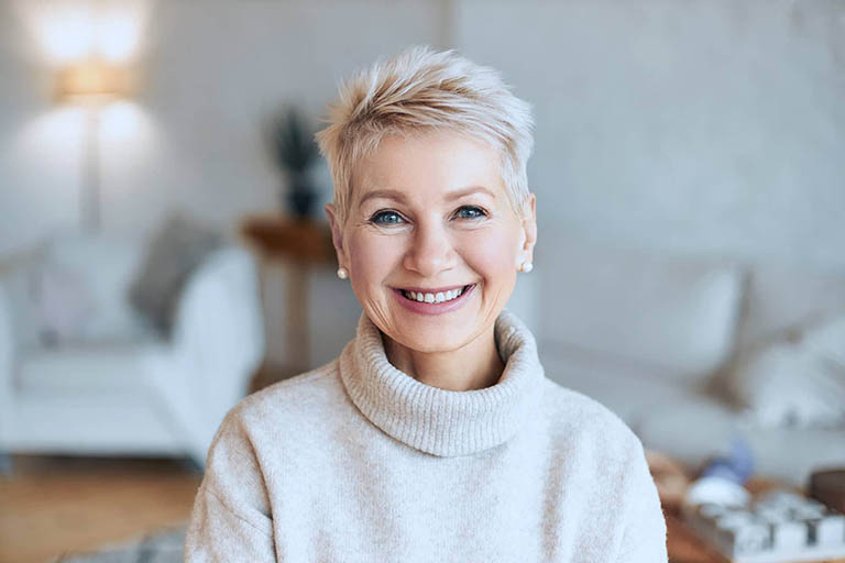 Frau mittleren Alters mit modernem unauffälligen Zahnersatz